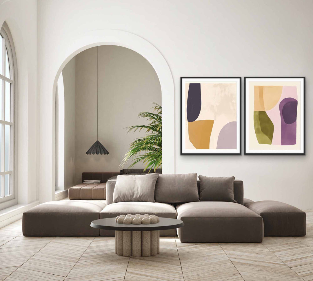 Modern abstract art prints in black frames, featuring soft earthy tones and geometric shapes.
