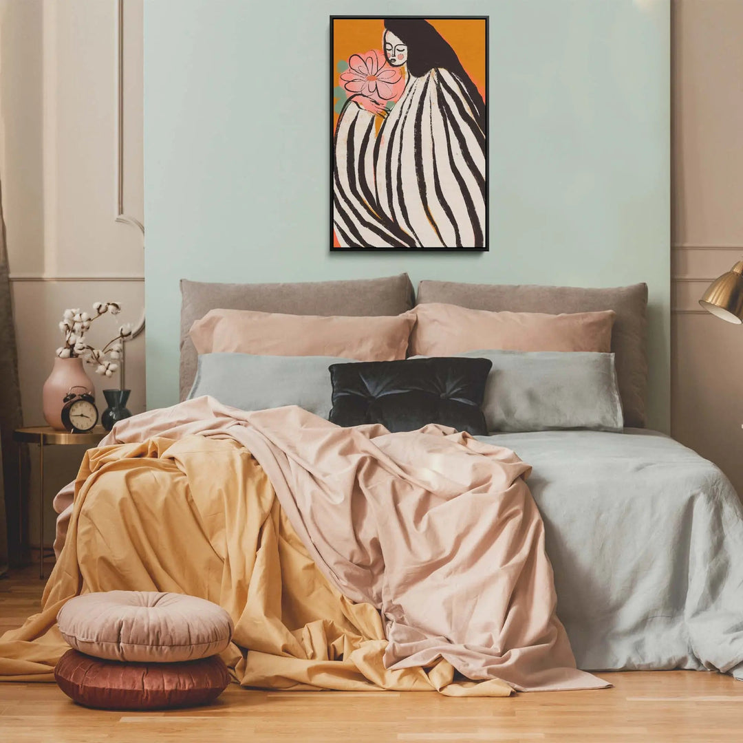 A framed print titled a silent moment by Treechild featuring a woman in black and white stripes holding a pink flower on orange background