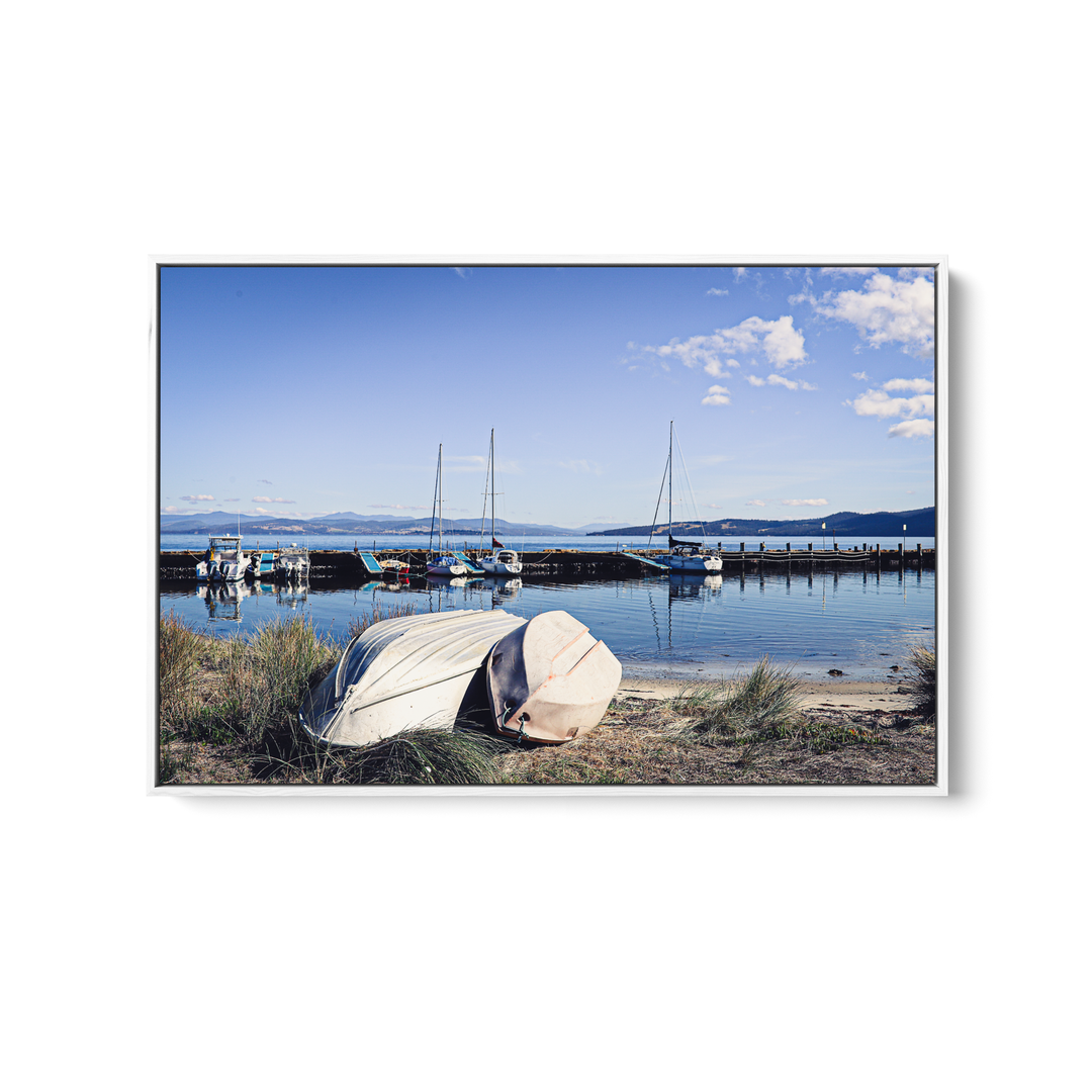 A framed photographic print of a serene harbor with beige boats and sailboats at alonnah bruny island tasmania by edwina cameron