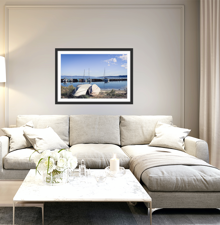 Black-framed photographic print of Alonnah harbor with sailboats and white rocks under a blue sky by Edwina Cameron