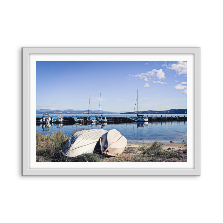 White-framed photographic print of serene harbor with boats and calm water under blue sky alonnah bruny island tasmania
