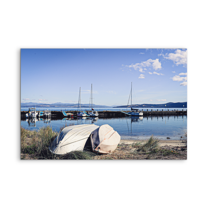 Beige canvas print of a serene lakeside scene with boats at alonnah bruny island tasmania by edwina cameron