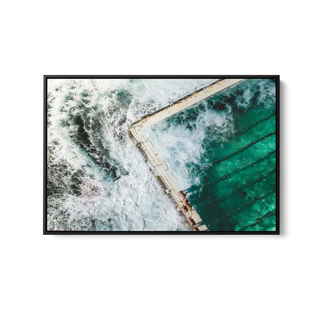 A framed fine art print featuring a turquoise pool with white waves in a sleek black frame for ocean swimming decor