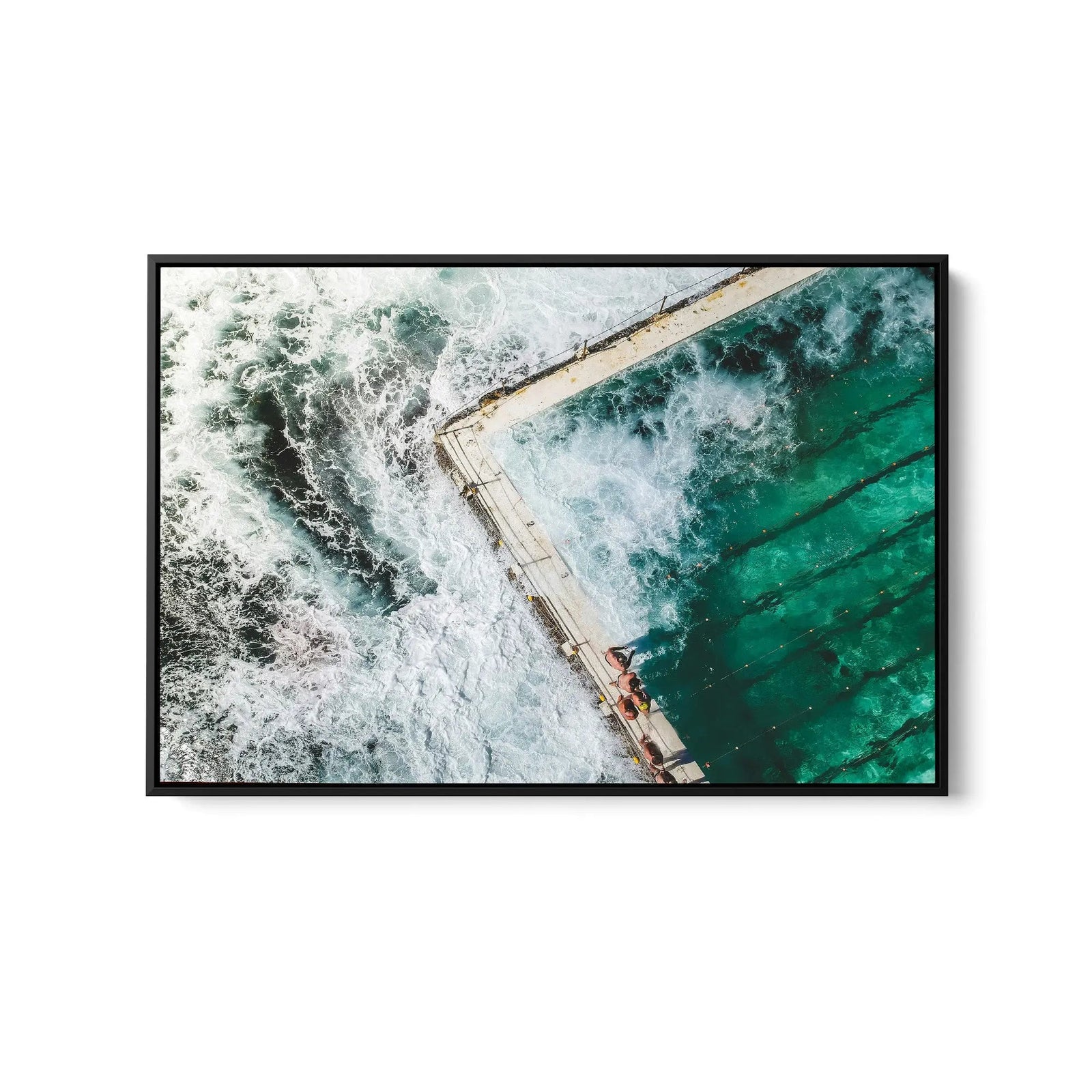 A framed fine art print featuring a turquoise pool with white waves in a sleek black frame for ocean swimming decor