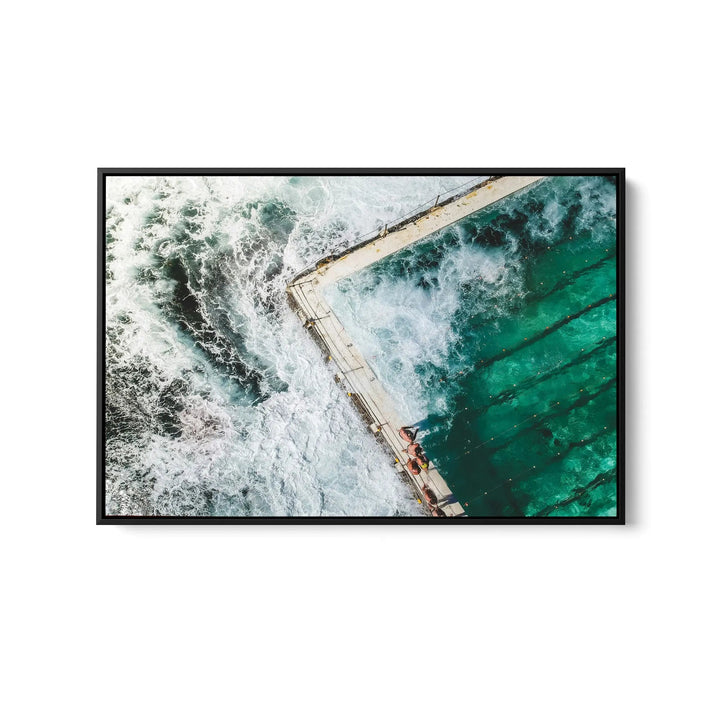 A framed fine art print featuring a turquoise pool with white waves in a sleek black frame for ocean swimming decor