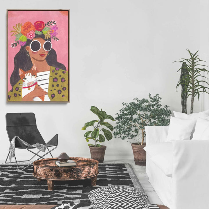 Cat Lady by Caroline Bonne Muller vibrant pink-framed canvas print of woman with sunglasses holding orange cat and floral headpiece