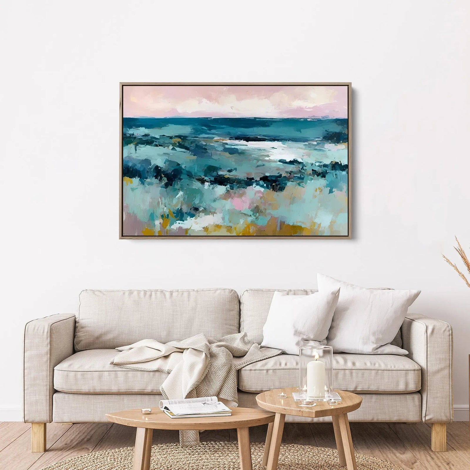 A framed coastal abstract landscape canvas print with soft pink and teal hues in a simple wooden frame