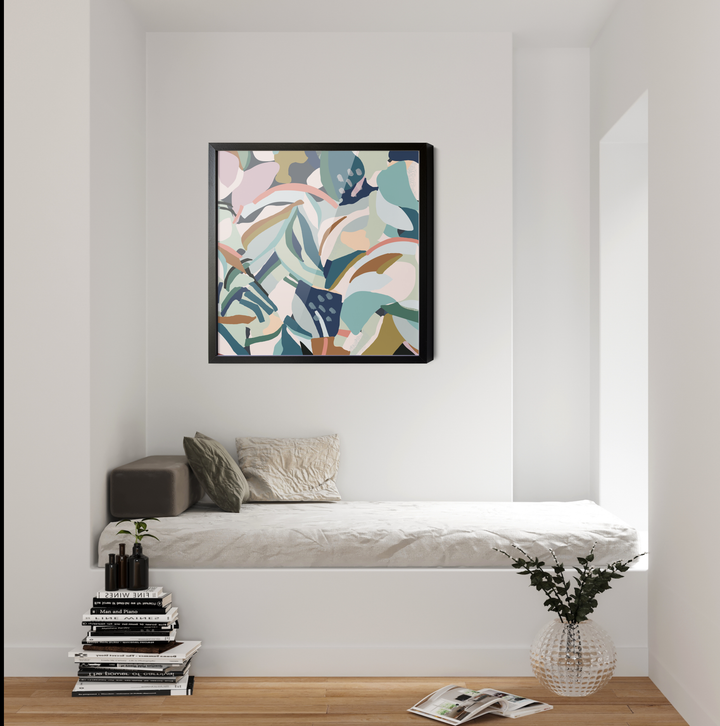 A framed original abstract canvas artwork flurry with soft pastel teal leaf shapes hanging above a white bench