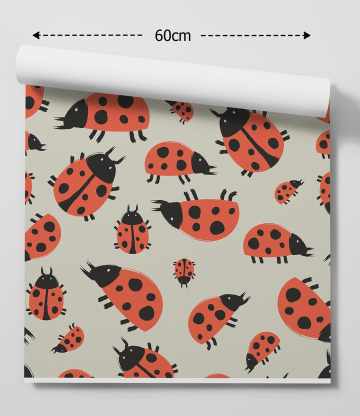 A roll of ladybug dance peel and stick removable wallpaper with red ladybugs on a light beige background