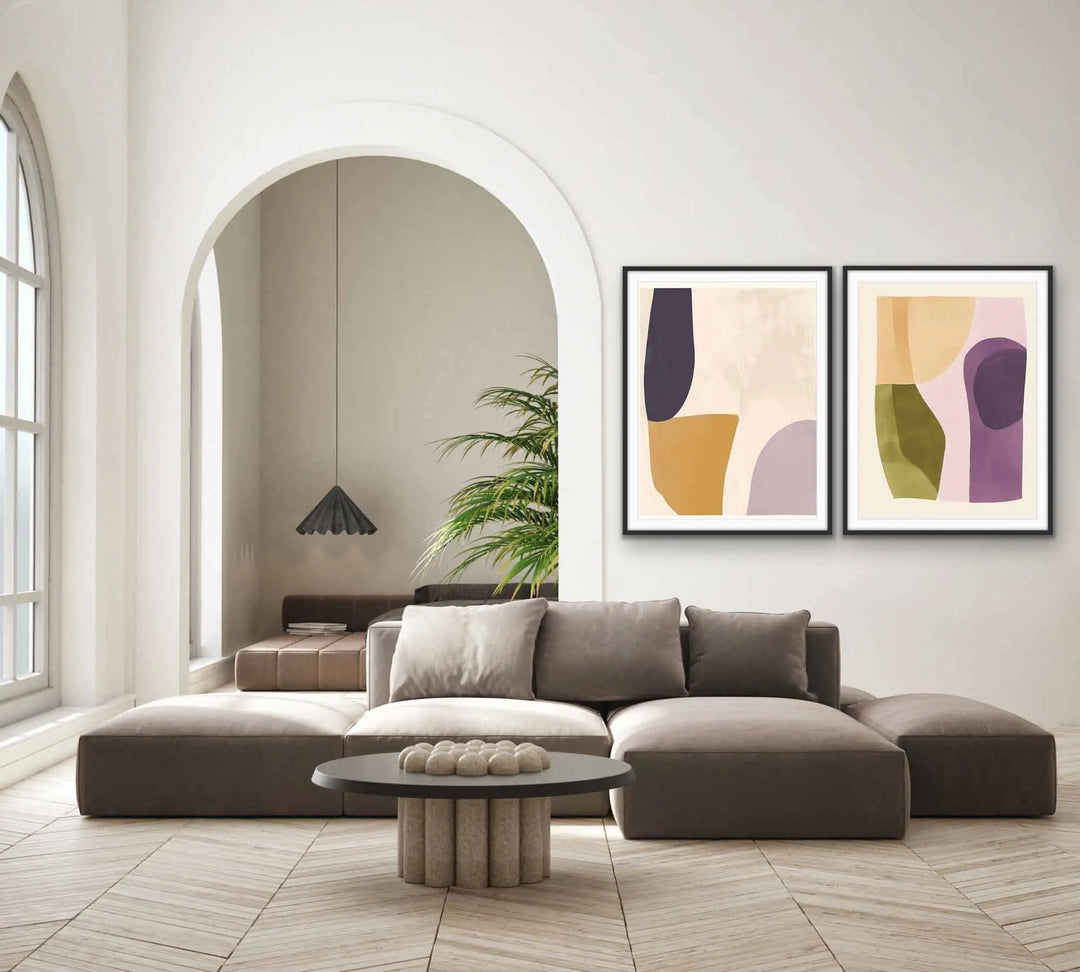 Modern abstract art prints in black frames, featuring soft earthy tones and geometric shapes.