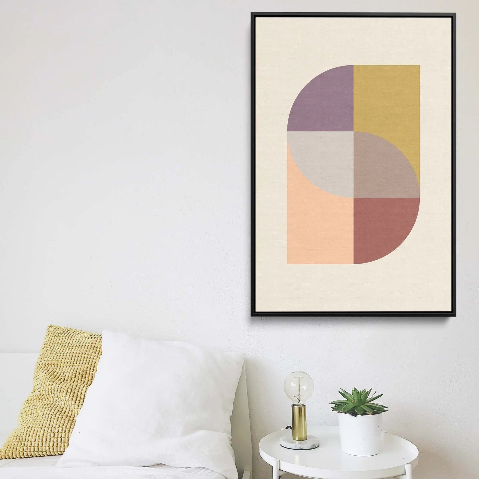 A framed geometric stretched canvas print with pastel purple yellow peach and terracotta hues on off-white background