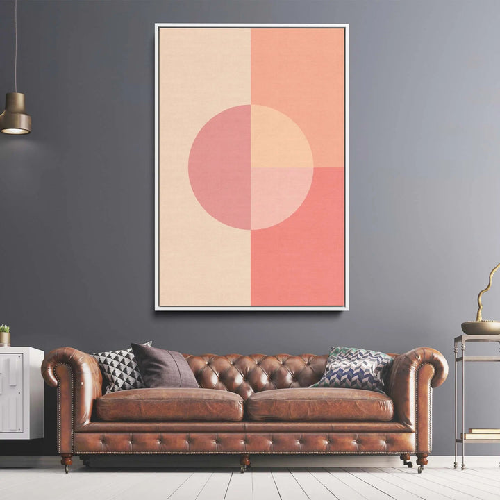 Brown leather tufted chesterfield sofa with rolled arms and nailhead trim next to peach 35 pastel geometric canvas print