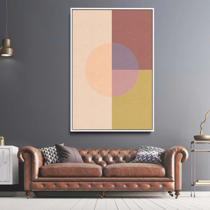 Brown leather tufted chesterfield sofa with rolled arms and nailhead trim next to peach 36 pastel geometric canvas print