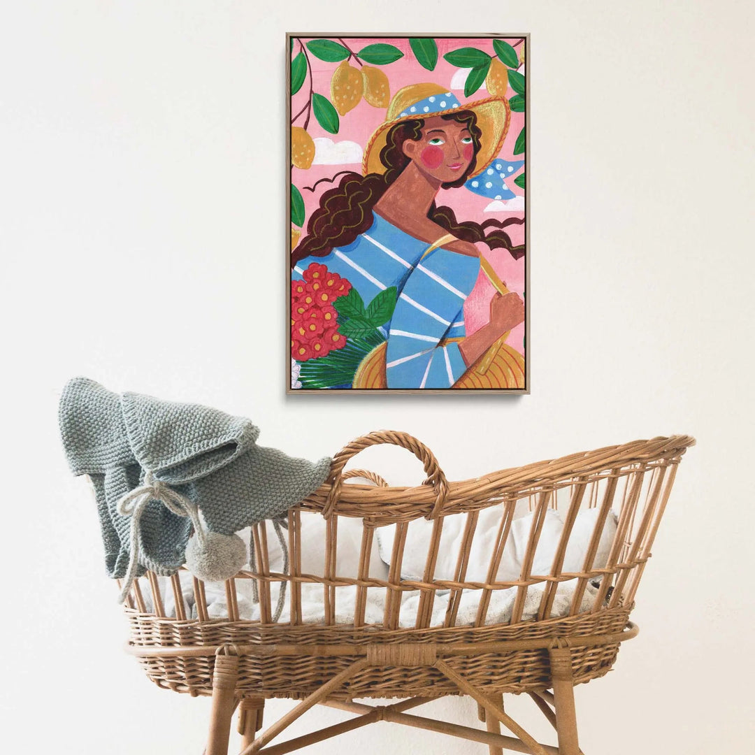 Woven rattan baby cradle with soft gray knitted blanket draped over side in portrait of woman amalfi coast print