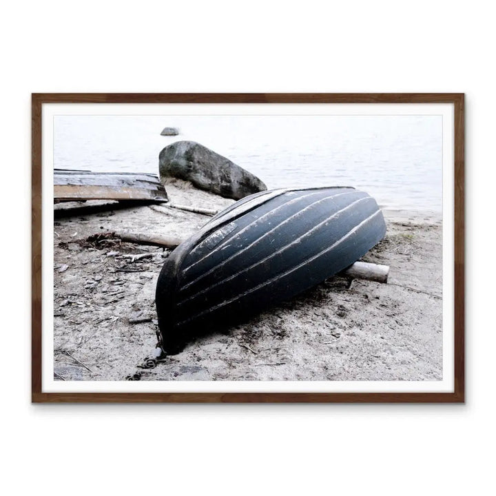 Rowboat on the shore stretched canvas photographic print of a black ribbed canoe resting on sandy shore