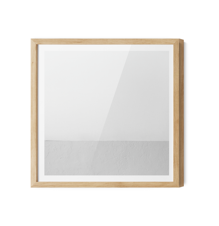 A minimalist square picture frame with a light oak wood finish displaying white grey geometric wall art canvas print