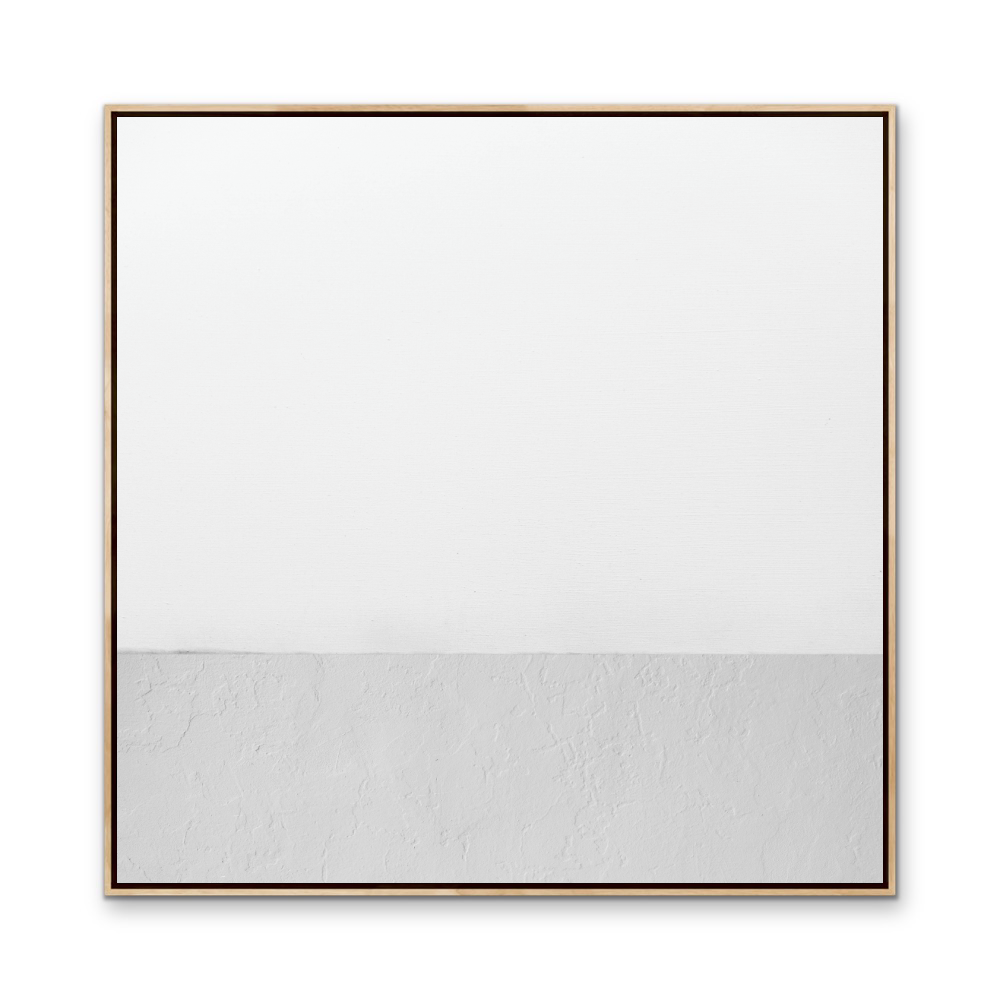 White whispers minimalist abstract canvas print with white and textured gray halves in light wood frame with dark trim