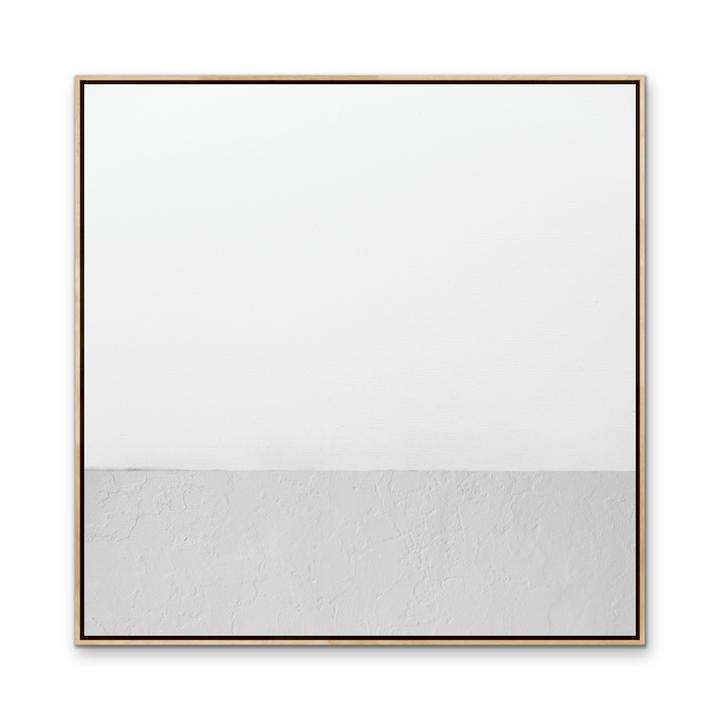 White whispers minimalist abstract canvas print with white and textured gray halves in light wood frame with dark trim
