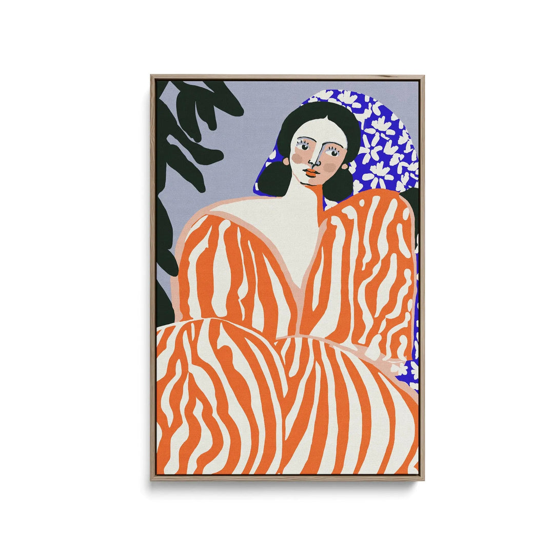 A vibrant orange and white zebra-striped contemporary art print of a woman in a floral headscarf framed in light wood