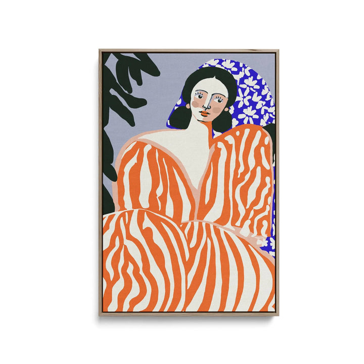 A vibrant orange and white zebra-striped contemporary art print of a woman in a floral headscarf framed in light wood