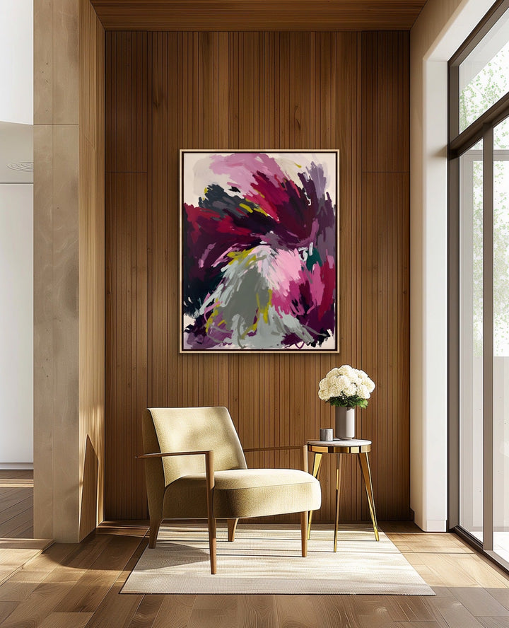 A vibrant abstract artwork titled yield with magenta purple and gray strokes in a white frame on a wooden wall