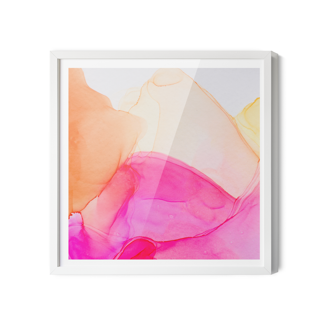 A vibrant abstract alcohol ink painting art print in a white frame featuring pink peach and yellow gradients